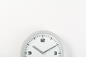 White wall clock with a yellow used hanging on the wall. Minimalist image of a wall clock on a light gray background with copy space