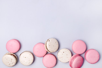 Wall Mural - Pink and White Macarons on Blue Background French Dessert Caramel and Strawberry Macarons Horizontal Flat Lay Copy Space