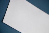 Fototapeta Big Ben - Cropped image of a blank white paper on dark blue surface