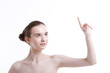 © MDBPIXS - Shirtless beautiful young woman pointing up against white background