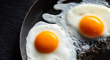 Fried Eggs In A Pan. Black Background