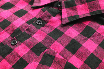 Colorful plaid shirt close up view of bright vivid pink and black tartan pattern clothes. Trendy casual light purple lumberjack shirt, plaid cotton material top 