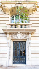 Paris, a wooden door, typical building in the Marais, with a beautiful stone balcony