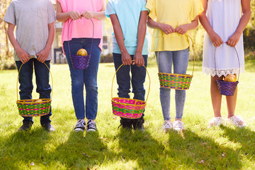 Wall Mural - Close Up Of Five Children Holding Baskets On Easter Egg Hunt In Garden