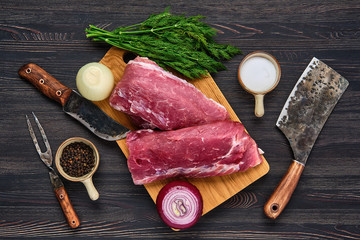 Wall Mural - Overhead view of raw pork fillet on wooden cutting board with spice