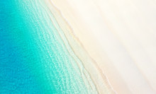 Natural Textured Summer Background For Vacation. White Golden Sand On The Beach And Turquoise Water Of The Ocean Sea With The Incoming Wave, Copy Space.