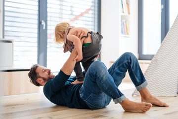 Wall Mural - Father with small boy playing indoors in bedroom, having fun.