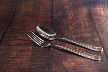 Stainless fork and spoon on wooden table