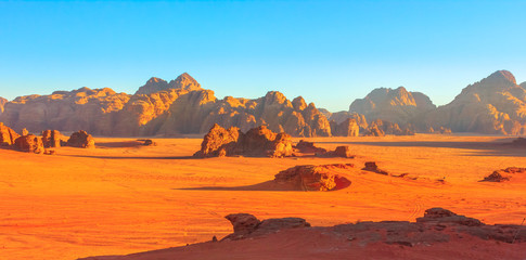 Banner panorama of scenic landscape of Wadi Rum Desert and Valley of the Moon at sunset light in southern Jordan. Popular tourist destination for spectacular sandstone and granite rock.