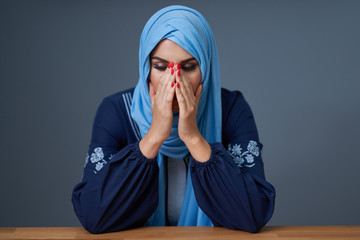 Unhappy muslim female student learning at home