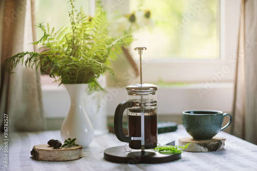 summer morning at wooden cottage kitchen with coffee and wild ferns in vase