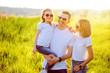 © ZaStock - Photo A happy family in white T-shirts, sunglasses and jeans in the park. Summer.