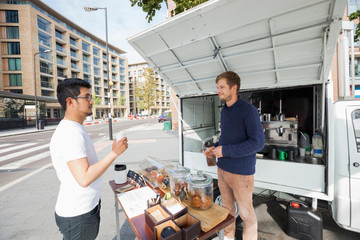 Wall Mural - Vendor looking customer at mobile coffee shop on street