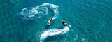 Aerial drone ultra wide photo of jet ski watercraft couple cruising in high speed in tropical exotic bay with turquoise sea
