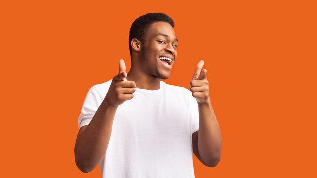 happy afro guy choosing you over orange background