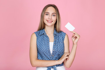 Young woman holding blank business card on pink background