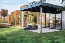 Two Black Loungers Under An Overhang To Enjoy The Sun In The Beautiful Autumn Garden