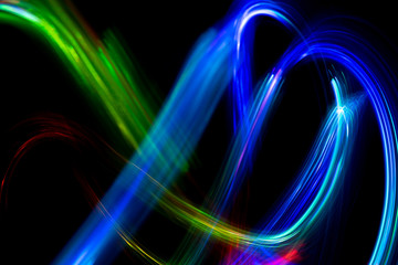Wall Mural - Abstract color pattern of luminous stripes on a black background, bright and smooth color streaks