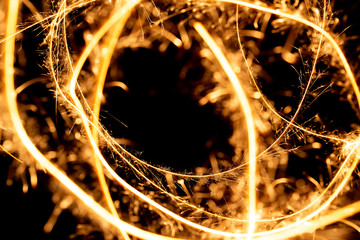 Wall Mural - Abstract pattern of sparks and bright light beams of Golden color on a black background