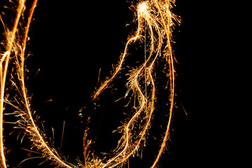 Wall Mural - Abstract pattern of sparks and bright light beams of Golden color on a black background