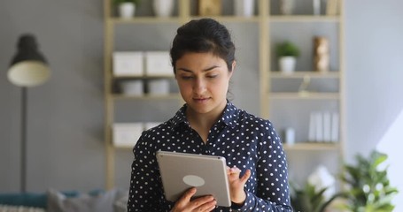 Canvas Print - Indian woman using digital tablet online apps at home office