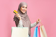 © Prostock-studio - Happy arabic girl with credit card and bright paper shopper bags