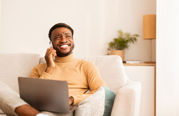 Poster - Happy Black Man Talking On Cellphone Working On Laptop Indoor