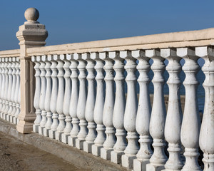 White, decorative fence made of concrete.