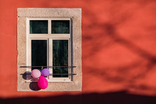 Colorful Balloons In A Window On Red House
