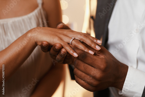 Fotomural Afro guy putting ring on his girlfriend finger