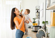 © Pixel-Shot - Mother feeding her little son in kitchen