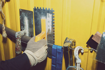 Poster - A set of tools on a yellow wall. Concept of work in a home workshop, doing homework. Tools such as the grinding wheel, saw hang on the wall.
