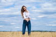 © Andrey_Arkusha - Young brunette woman in white shirt and blue jeans shorts