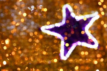 Background of blurred star with golden lights. defocused lights of festive garland