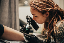 Hipster Woman With Tattoos Dreadlocks Makes Tattoo