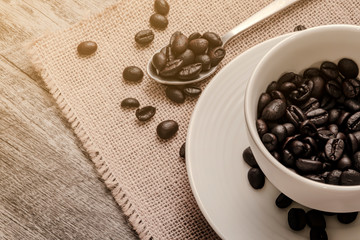 Wall Mural - roast coffee beans in a set of white coffee cup on a retro hemp sack