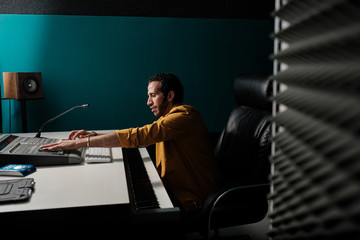 Wall Mural - Man working on music controllers at home studio