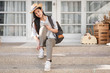 © weedezign - young traveler wearing shoe infront of house before go travel