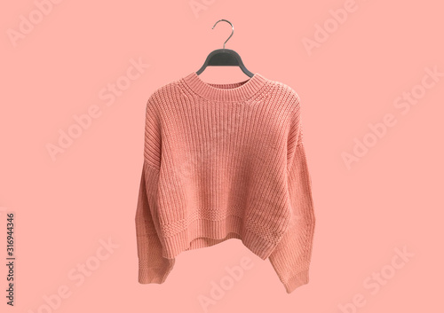 Fotografía Coral oversize knit sweater on hanger isolated on pink background