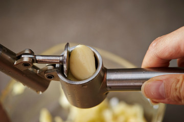 Canvas Print - Garlic crusher, crushing garlic clove