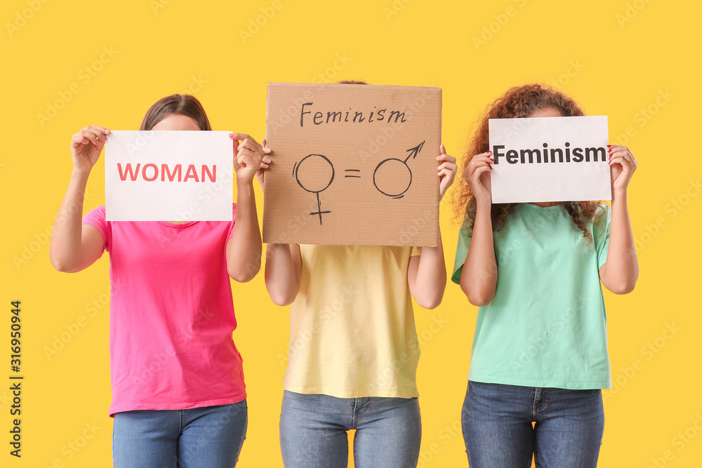 Young women on color background. Concept of feminism