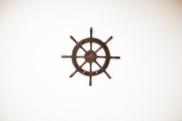 Poster - High angle shot of a small wooden ship's helm on a white surface