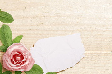 Sticker - Pink rose on a wooden table with empty paper for copy space