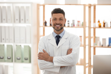 Portrait of happy male pharmacist in drugstore