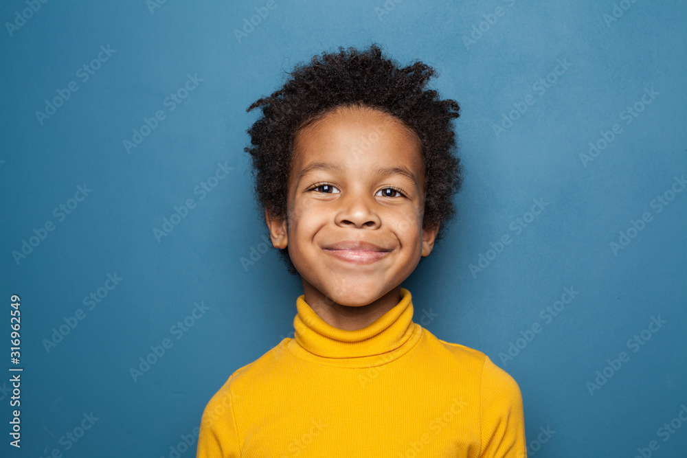 Happy child portrait. Little african american kid boy on blue background - obrazy, fototapety, plakaty 