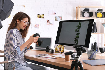 Wall Mural - Professional photographer with camera working at table in office