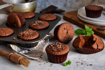 Wall Mural - Chocolate muffins with chocolate moss sauce and mint on a concrete background.