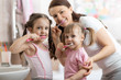 © Oksana Kuzmina - happy family mum and kids brushing their teeth