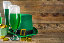 Traditional Irish Alcohol For St Patrick's Day Party. Different Glasses With Green Beer, With Golden Chocolate Coins Decor And Green Leprechaun Hat. Old Rustic Wooden Background Copy Space