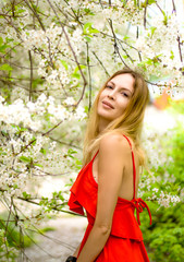 Sticker - Portrait of a beautiful girl among spring foliage and flowers